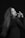 A woman with long hair poses in a stylish manner against a dark background. Her expression is confident, and she's wearing a black top. Her makeup is bold, emphasizing her eyes and lips. One hand is elegantly raised near her face, with fingers slightly splayed.