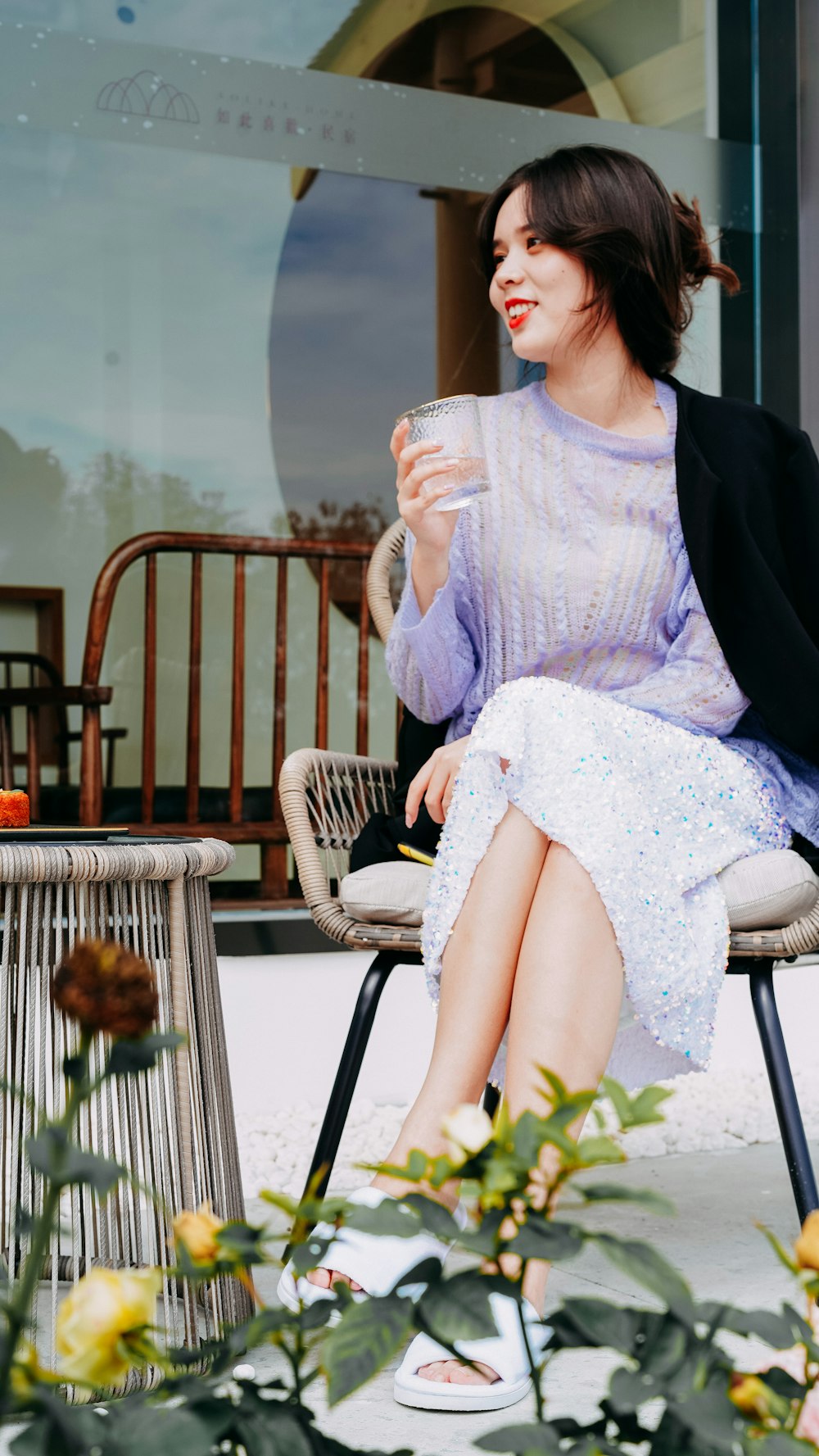 a woman sitting on a chair holding a cup of coffee