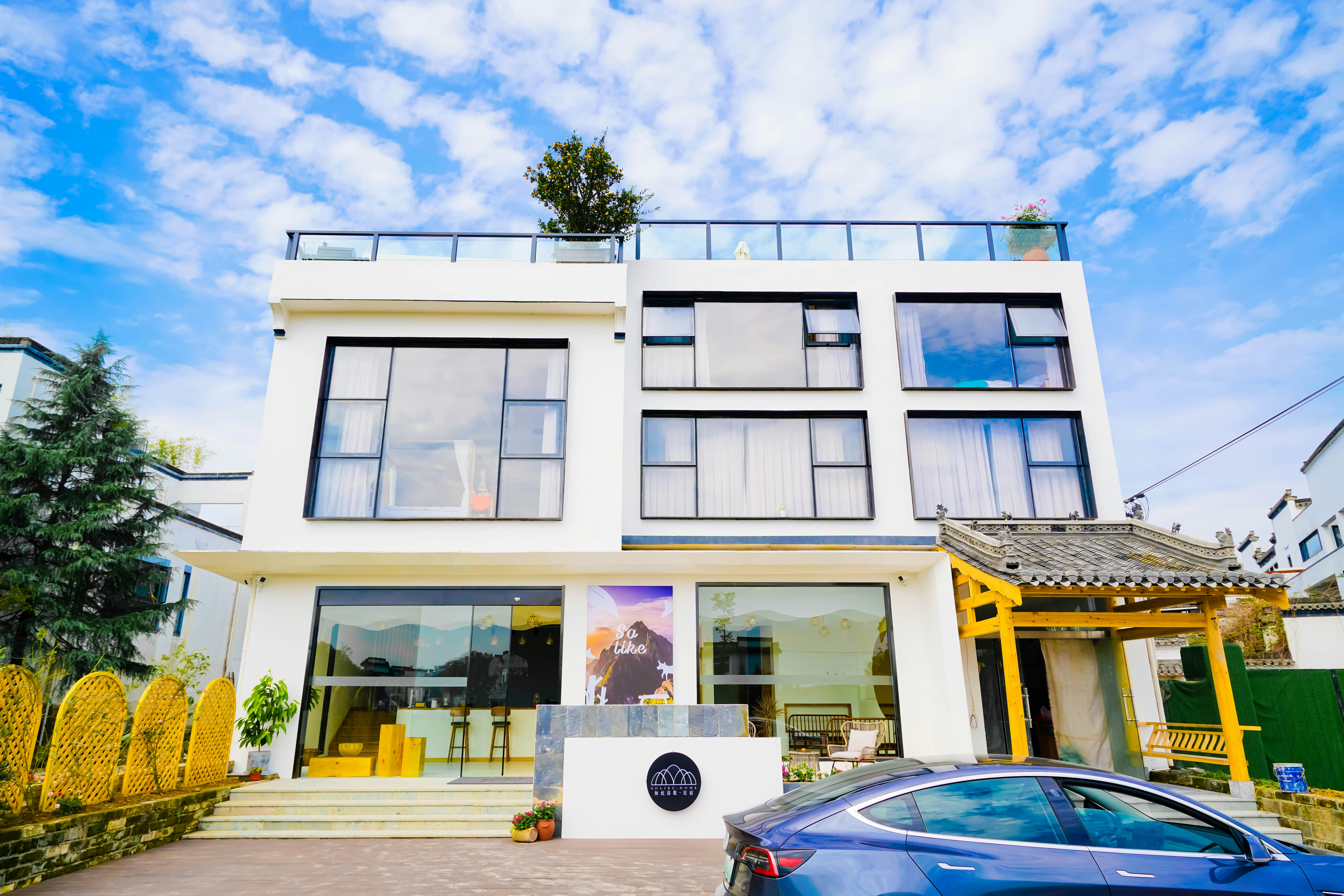 um carro azul estacionado em frente a um prédio branco