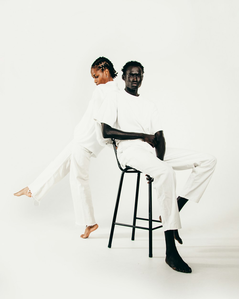 a man and a woman sitting on a stool