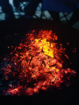 A close-up of glowing embers softly illuminating in the dark.