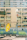 A tall residential building with numerous balconies and windows, some of which have laundry hanging. In the foreground, a bright yellow covering with cartoon illustrations is draped over a chair or small structure. A clean, modern urban atmosphere is present, with a mix of concrete and greenery.