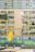 A tall residential building with numerous balconies and windows, some of which have laundry hanging. In the foreground, a bright yellow covering with cartoon illustrations is draped over a chair or small structure. A clean, modern urban atmosphere is present, with a mix of concrete and greenery.