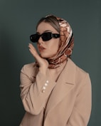 a woman wearing sunglasses and a scarf