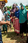 A group of women and youth gathered outdoors, engaged in a community workshop led by Kamal Chavan.