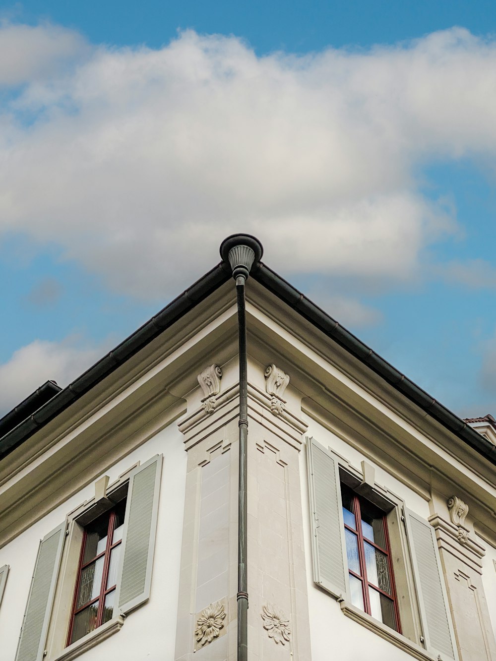 a tall white building with two windows and a clock