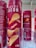 Cylindrical red containers with bold white text displaying 'SAVEUR BACON' and an image of chips and bacon strips are lined up on a shelf. The packaging indicates a 170g size with nutritional information and branding visible.