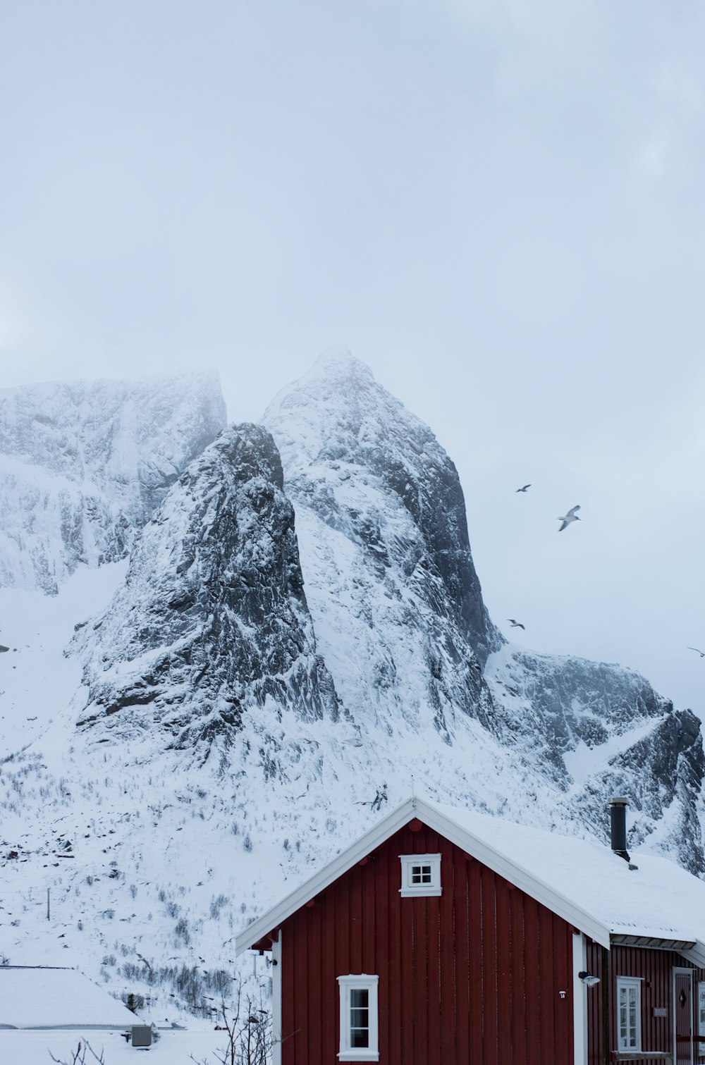 a red house with a mountain in the background