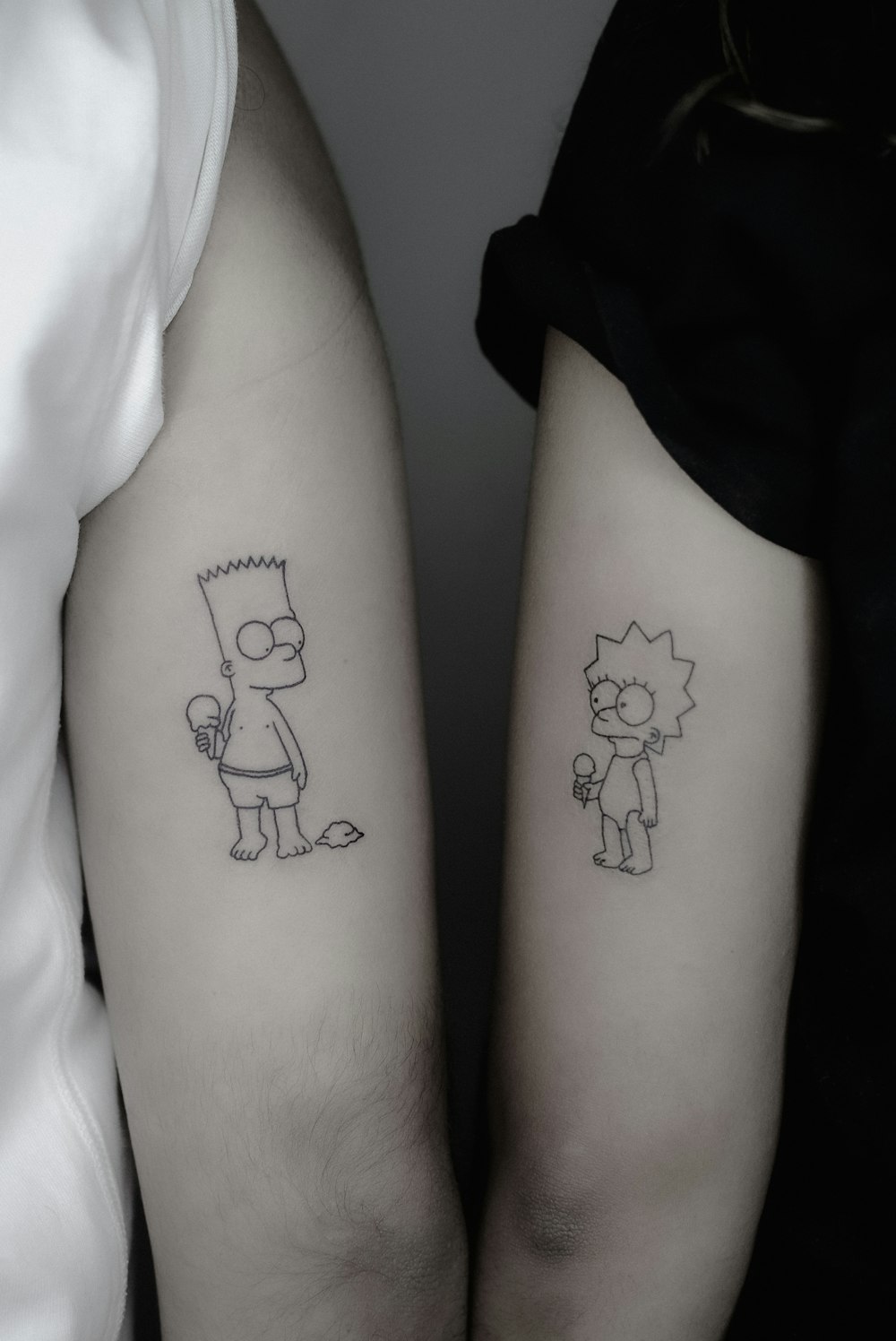 a couple of people with tattoos on their arms