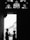A silhouetted couple stands in a doorway, surrounded by intricate stained glass elements above. The geometric details of the stained glass contrast with the soft, tender interaction between the figures, highlighting their profiles against the bright exterior light.