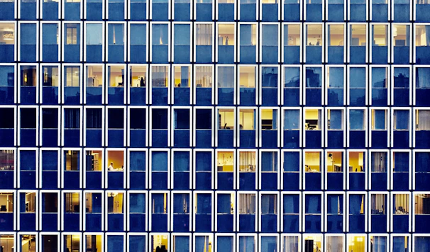 A neat row of spotless windows on a modern office facade, shining in daylight.
