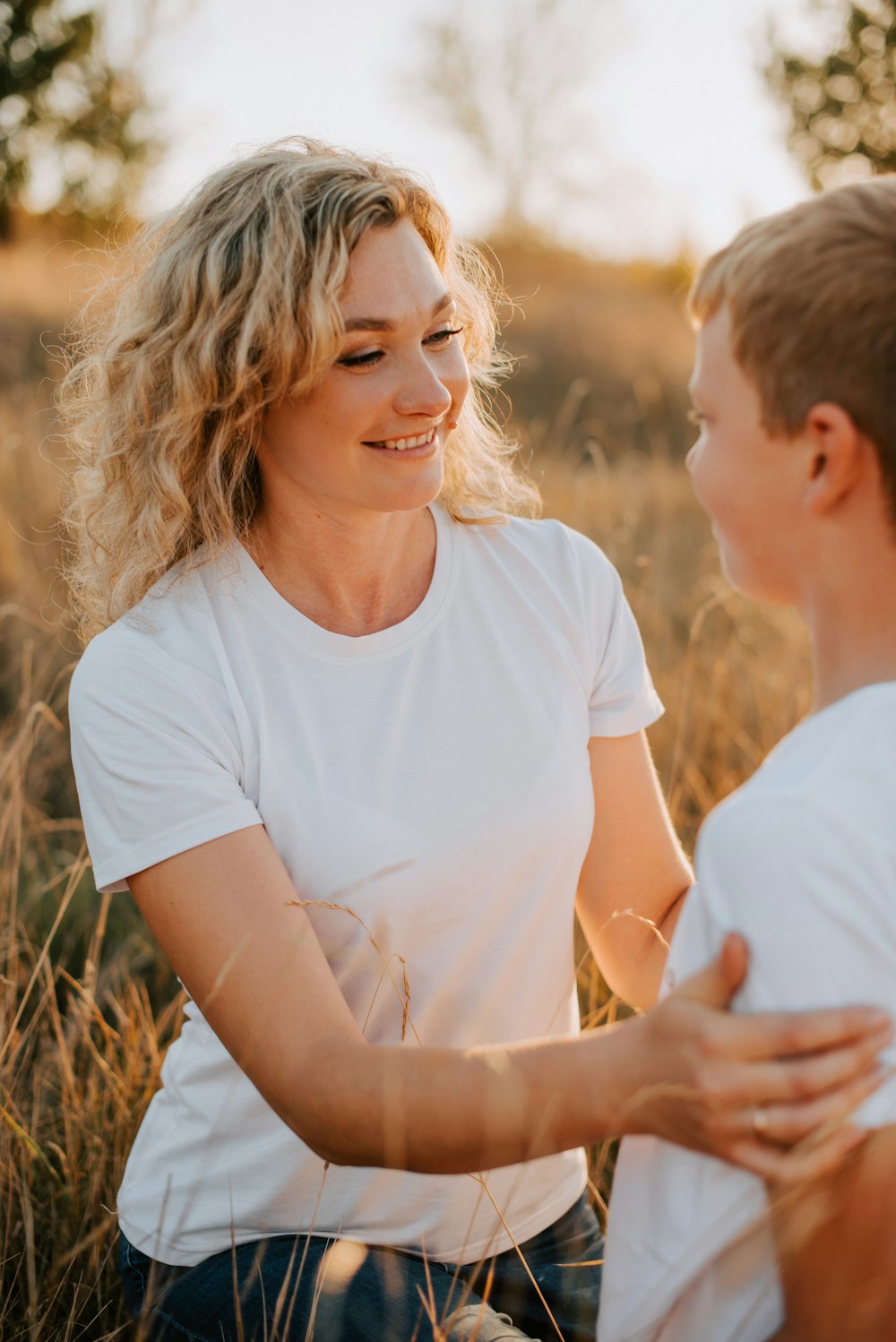 a woman and a boy sitting in a field