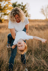 A cheerful mom in workout clothes playing with her kids in a sunlit living room.