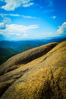 A scenic view of the Scottish Highlands with rolling hills and a clear blue sky.