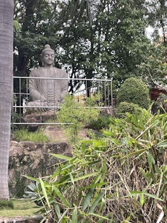 Huli Ajja statue standing watch over the tranquil meditation gardens embraced by nature’s greenery.