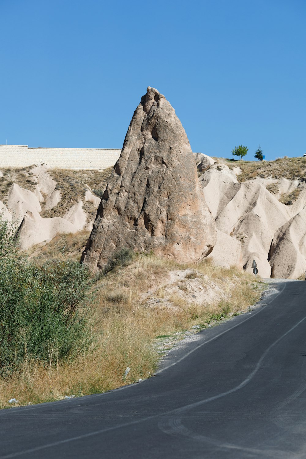 a large rock sitting on the side of a road