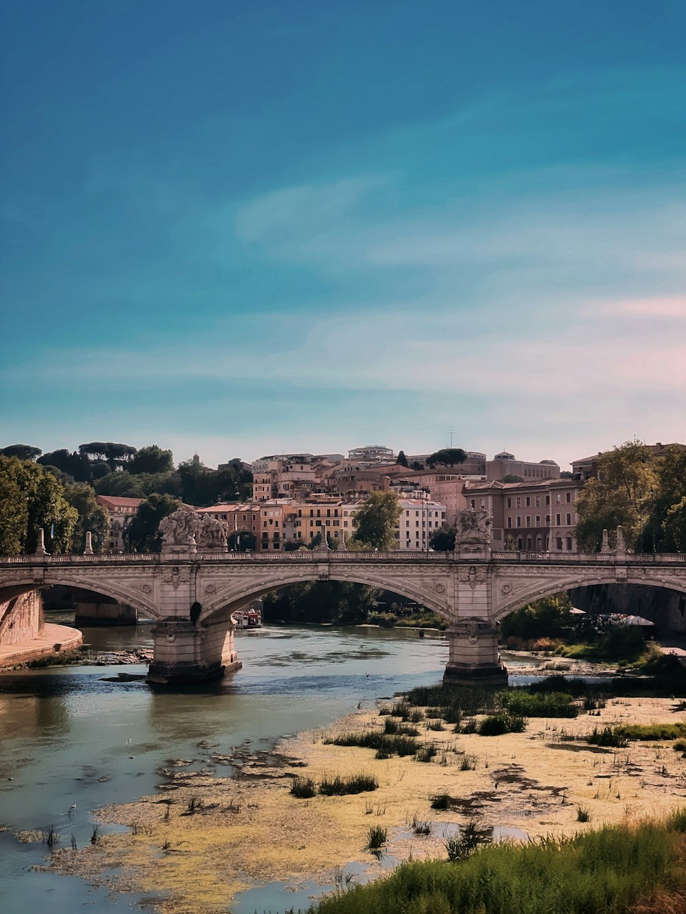 a bridge over a river with buildings in the background