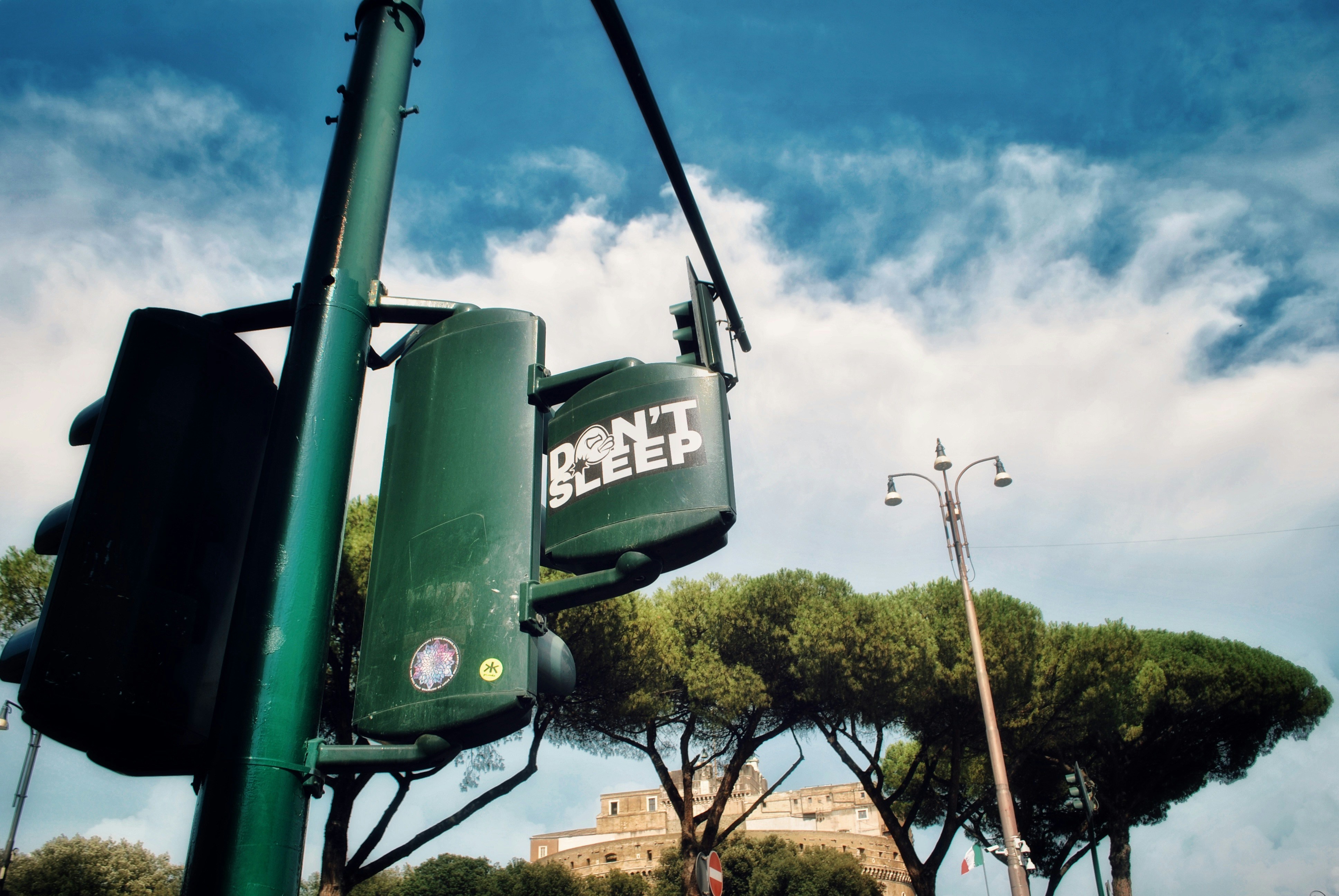 a green traffic light sitting next to a tall building