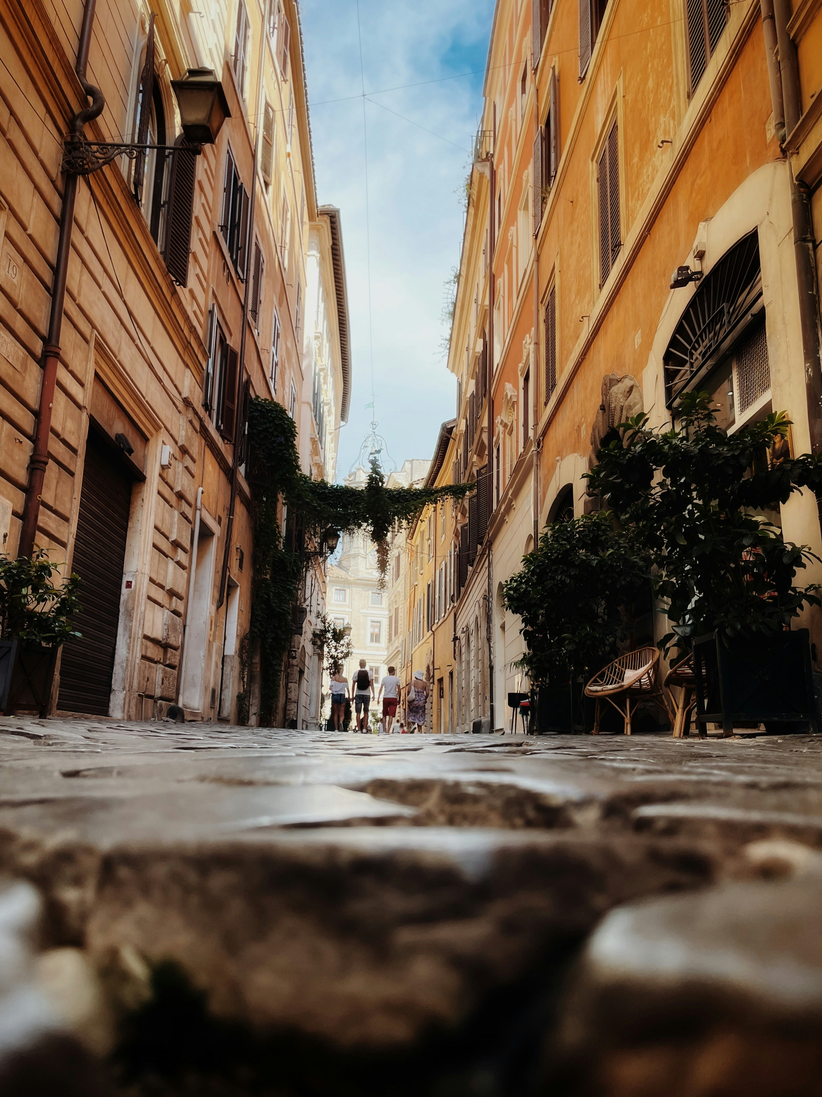 a narrow street with people walking down it