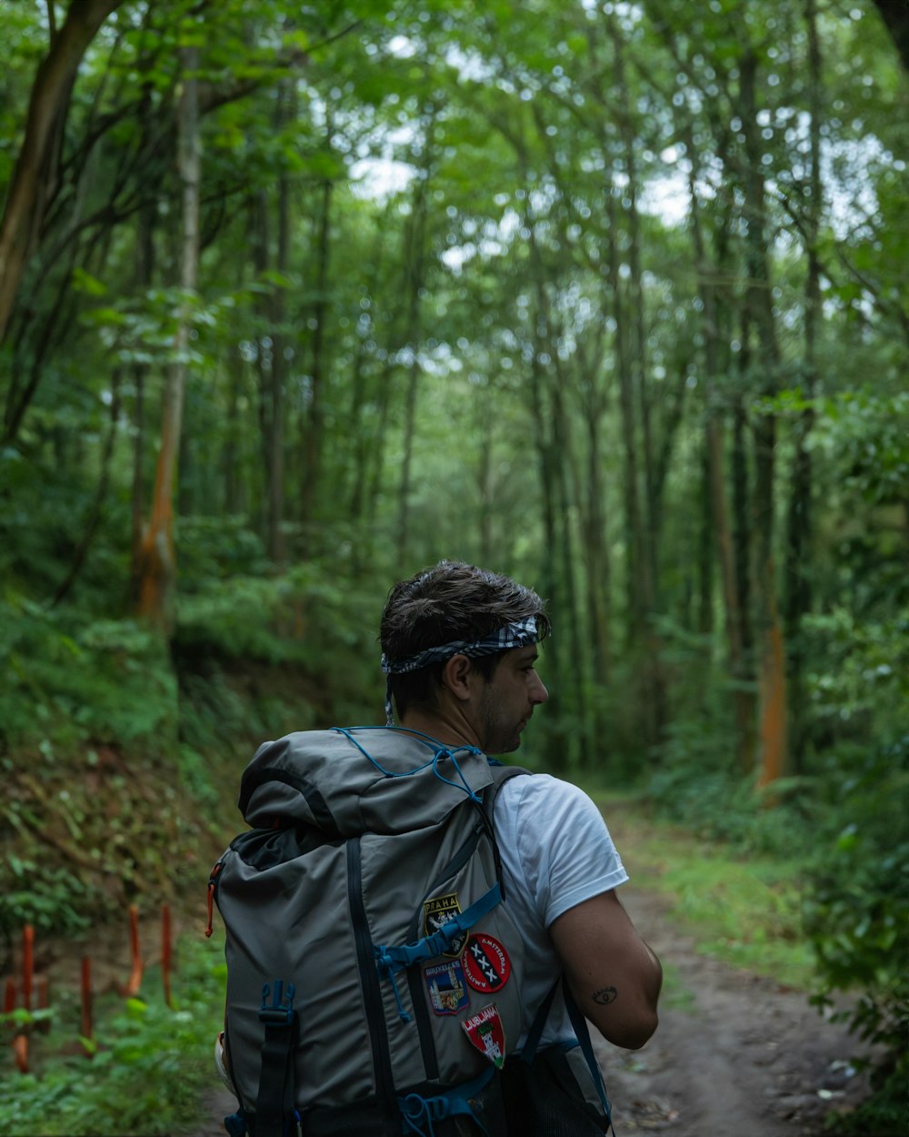 a man with a backpack is walking in the woods