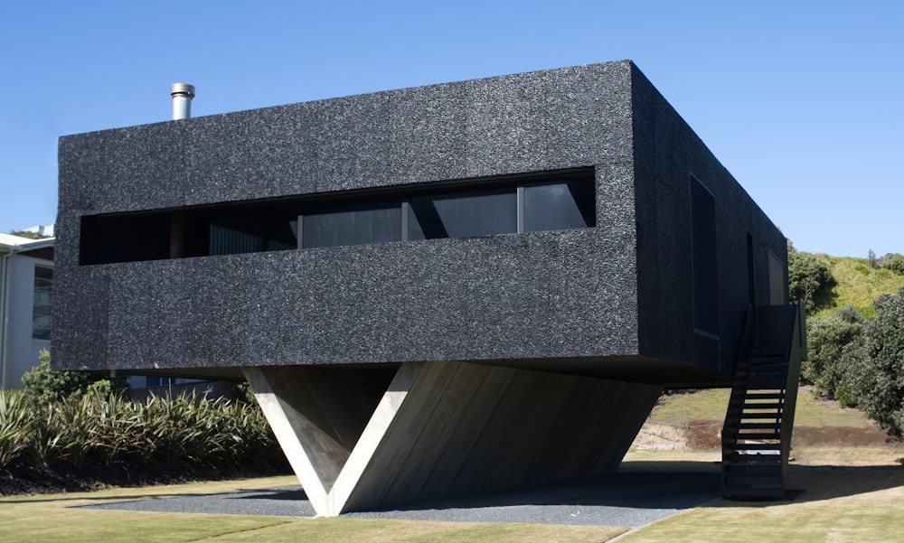 un bâtiment noir avec un escalier qui y mène