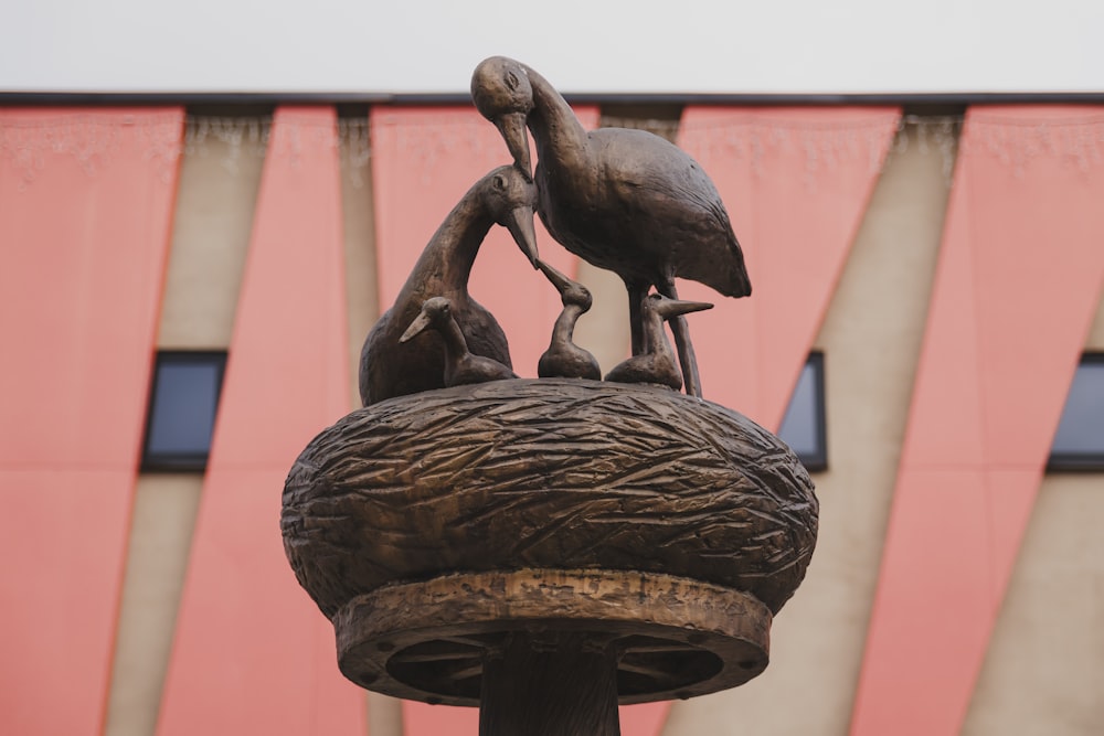 a statue of two birds on top of a pole