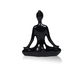 Close-up of a delicate meditation sculpture with subtle shadows highlighting its smooth contours against a charcoal background.