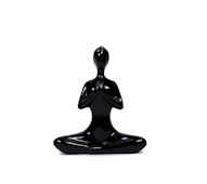 a black statue of a person sitting in a yoga position