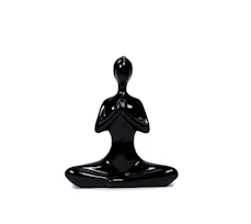 a black statue of a person sitting in a yoga position