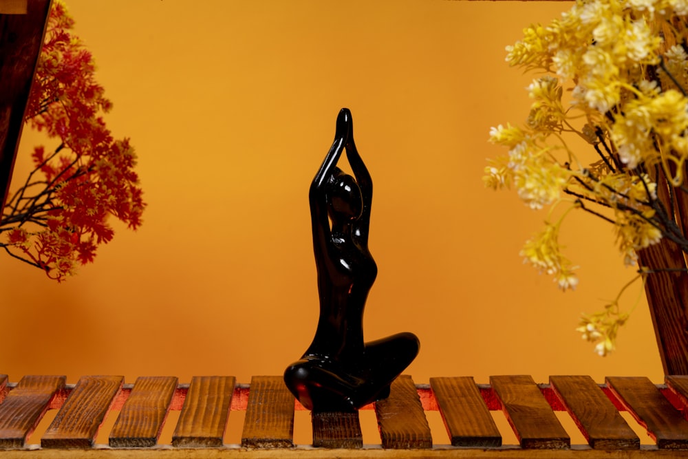 a statue of a woman sitting on a wooden table