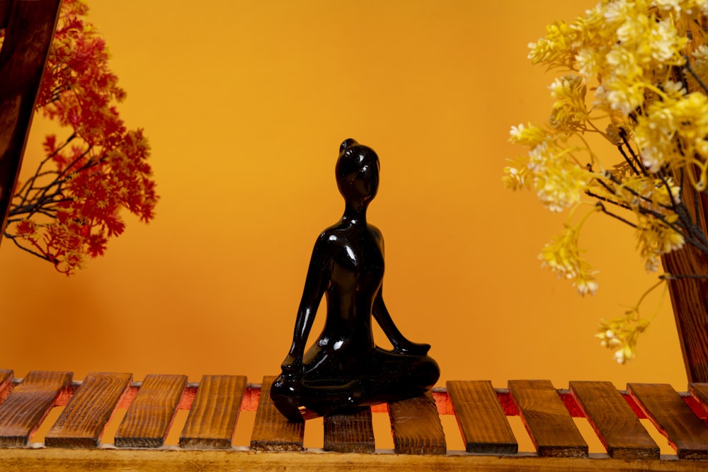 a buddha statue sitting on top of a wooden table