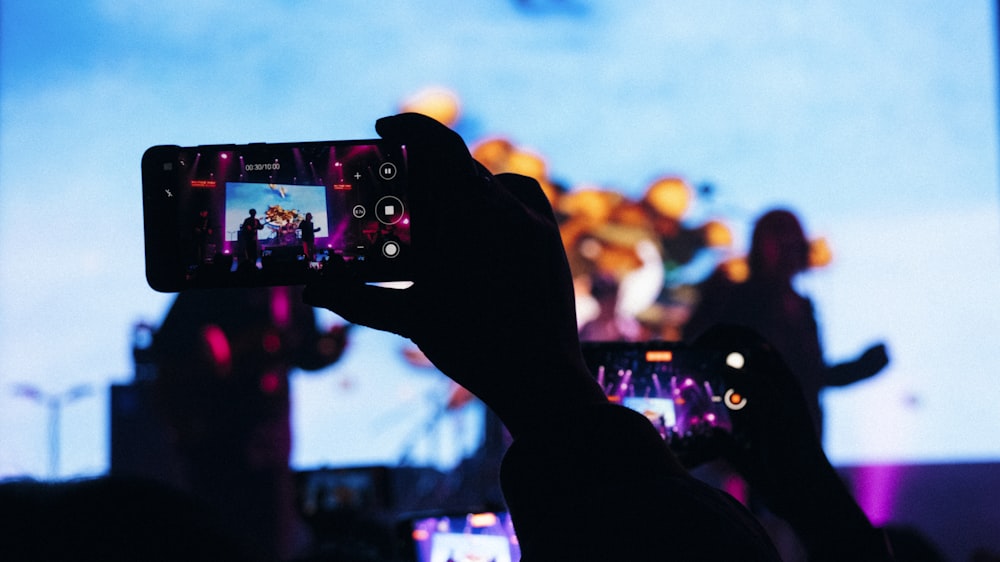 a person taking a picture with a cell phone