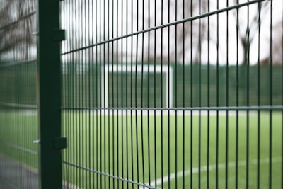 Close-up of durable sports field fencing mesh installed around a soccer field.