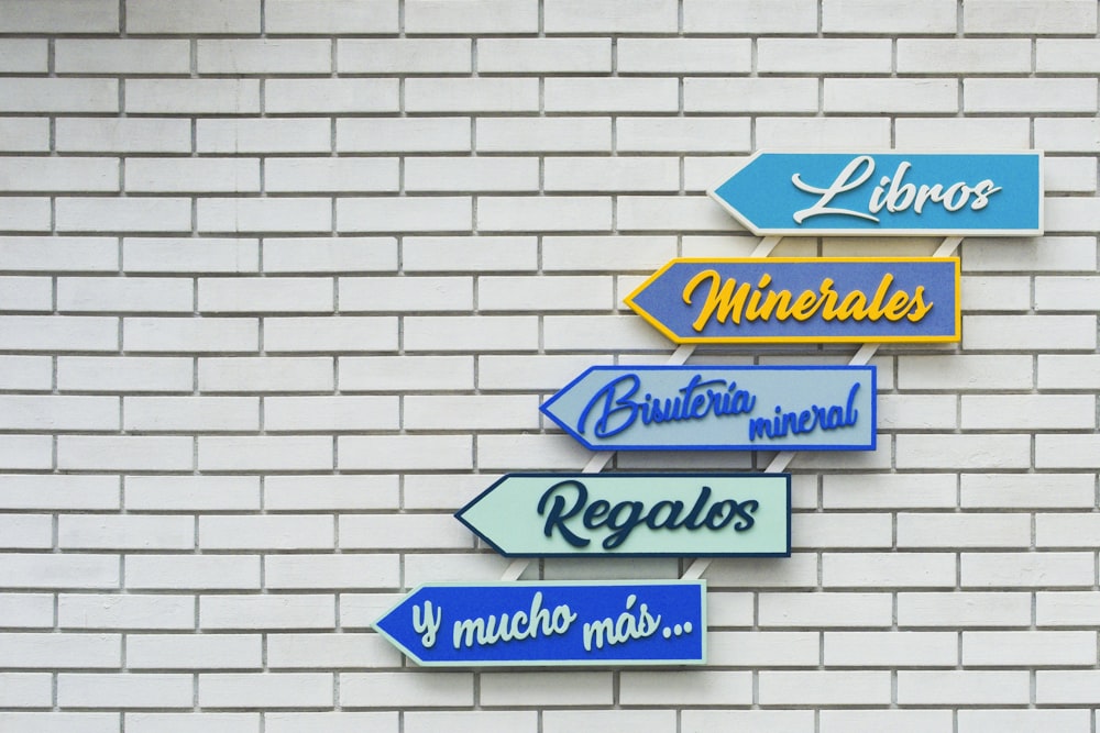 a white brick wall with a bunch of signs on it