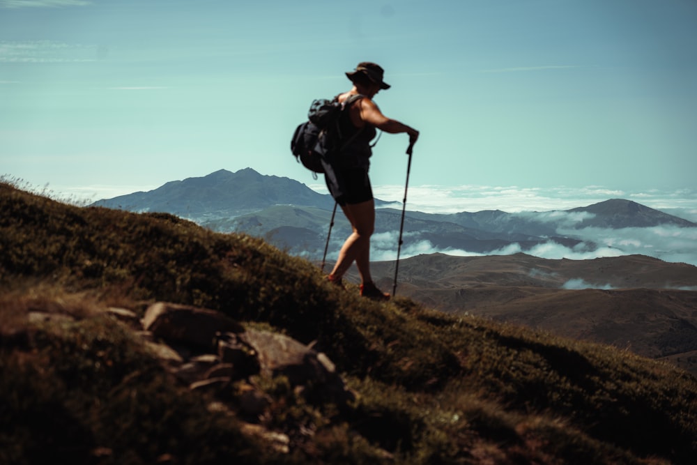 a man hiking up a hill with a backpack