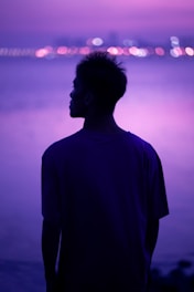 a man standing in front of a body of water