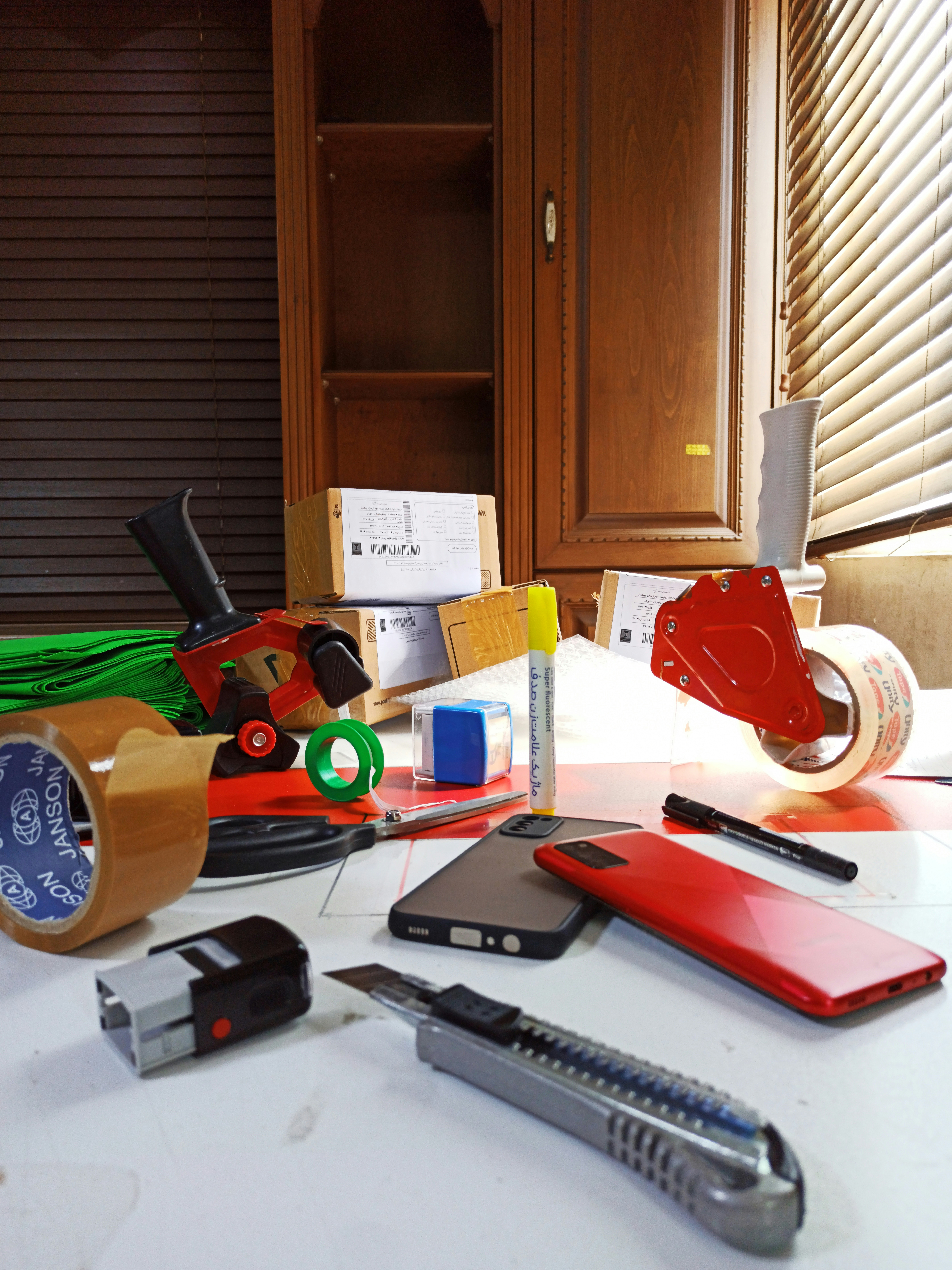 Packing materials including tape, wrap, and boxes on a table