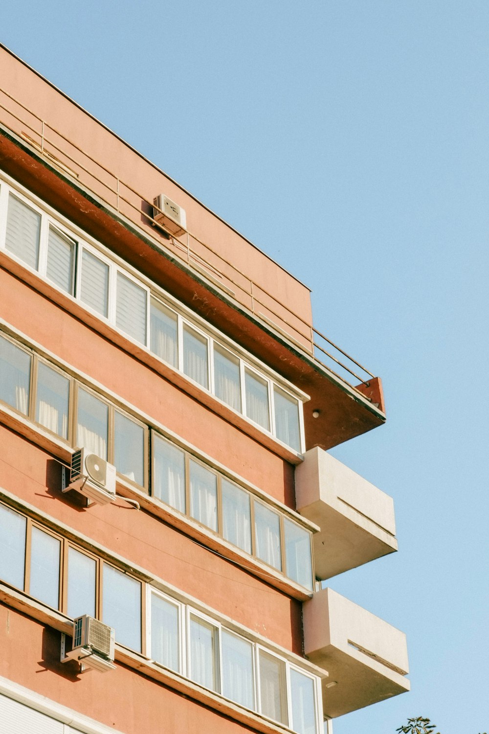 a tall building with lots of windows next to trees