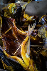 Close-up of smoked fish fillets with a golden-brown color on a rustic wooden board.