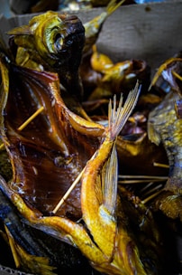 Close-up of smoked fish fillets with a golden-brown color on a rustic wooden board.