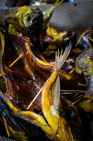 Close-up of golden smoked fish neatly arranged on rustic wooden boards, highlighting their rich texture and smoky glaze.