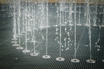 Close-up of powerful water jets cleaning a tiled outdoor floor.