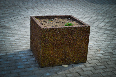 Large urban garden planter with robust mineral matrix, highlighted by shimmering mica and dark volcanic textures.
