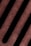 A close-up view of a metal surface with parallel rusty slits, creating a pattern. The texture appears rough, indicating corrosion and wear.