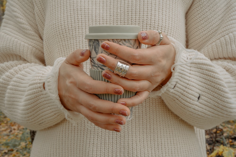 a woman holding a cup of coffee in her hands