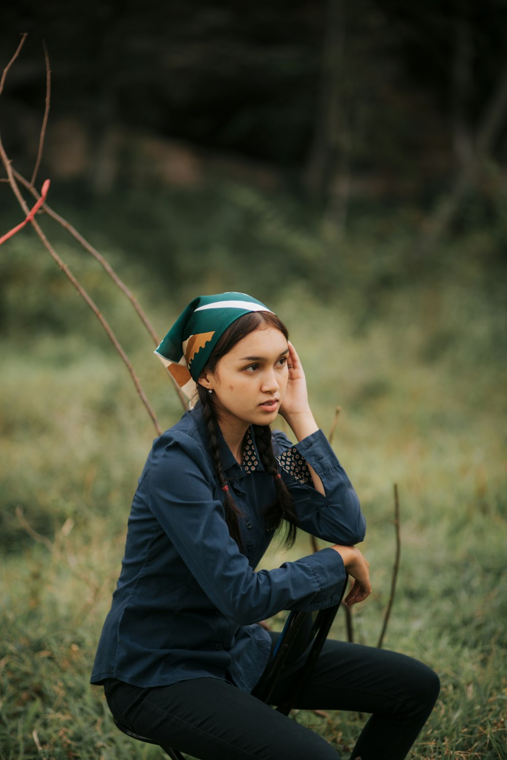 a woman sitting in a field with a hat on her head