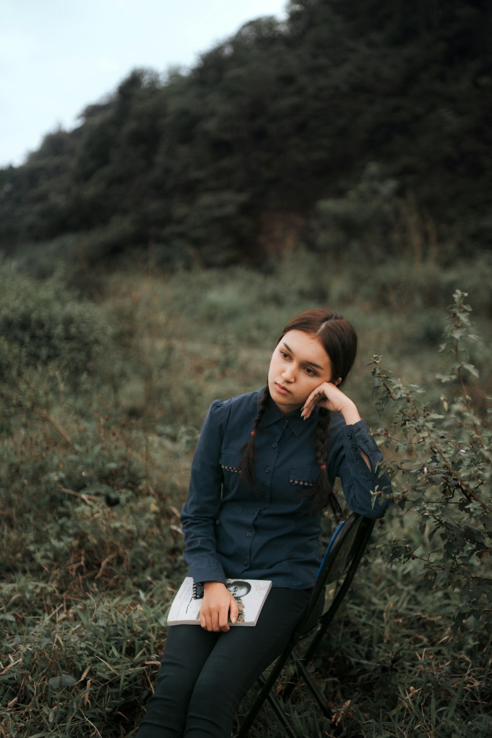 a woman sitting in a chair in a field