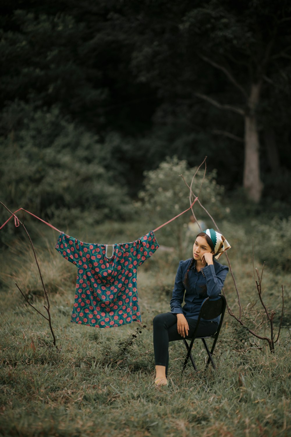 a woman sitting in a chair in a field