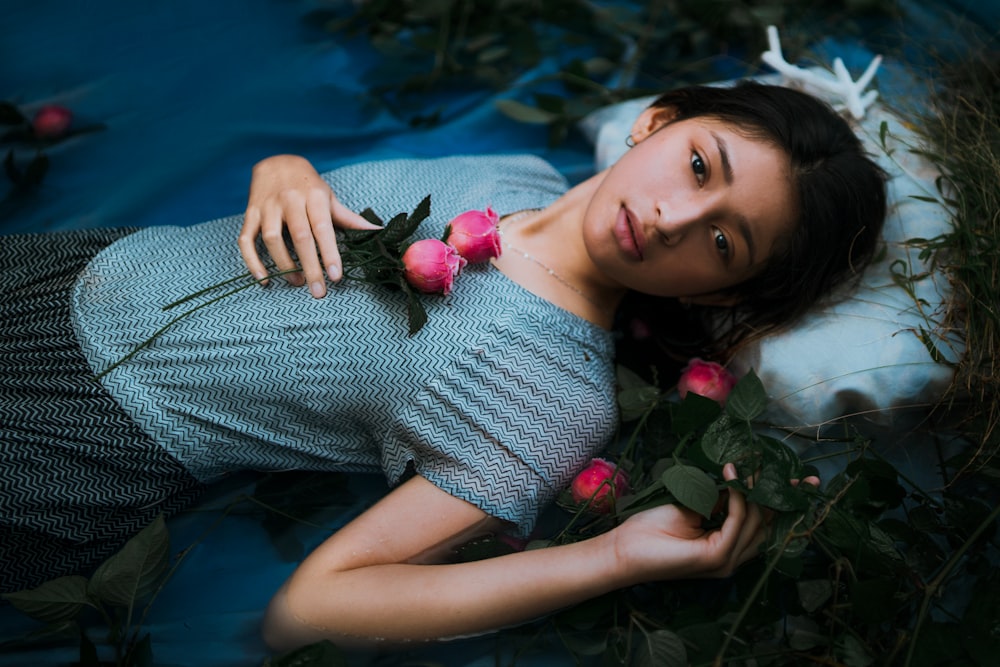 a woman laying on a bed of flowers