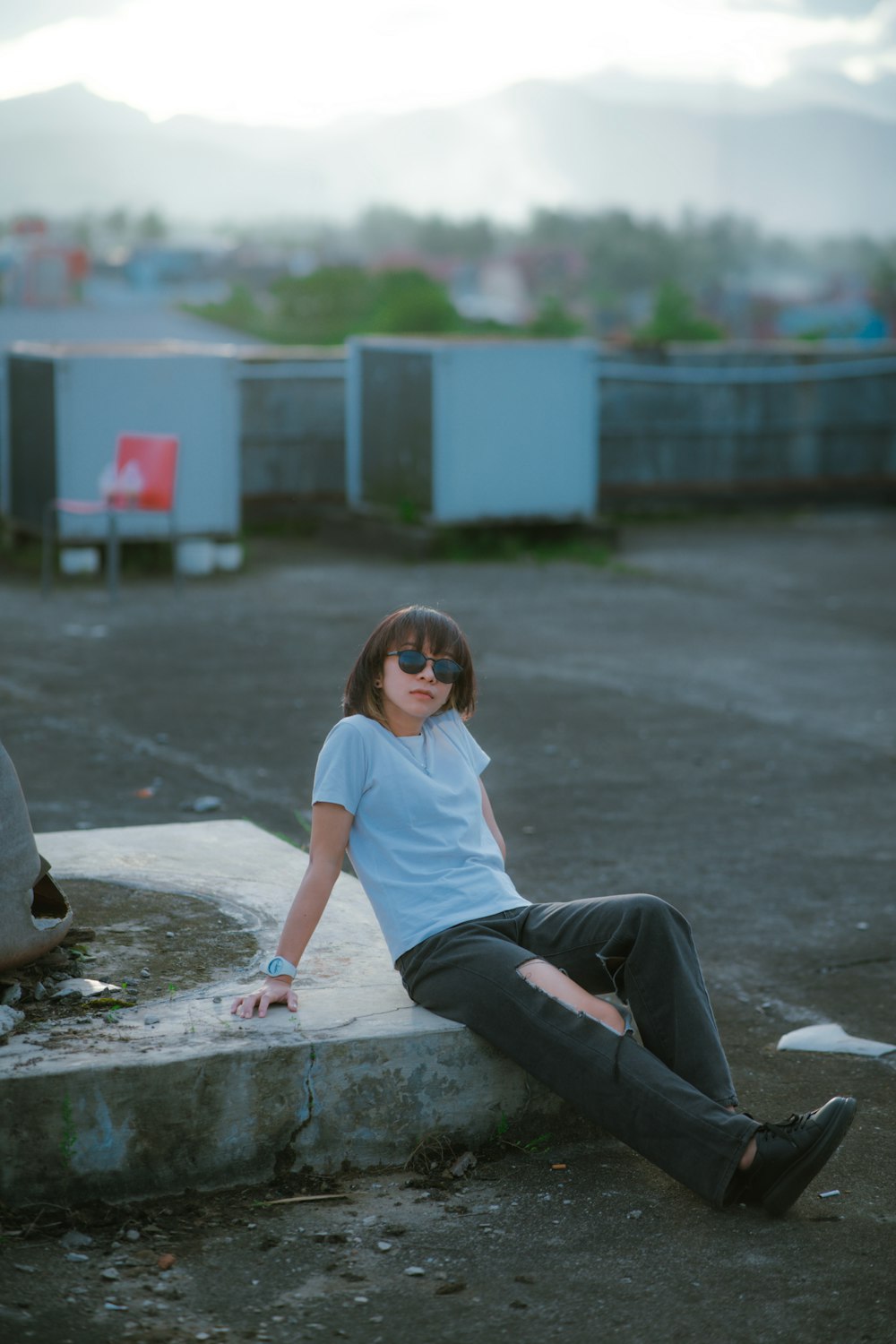 a woman sitting on top of a cement slab